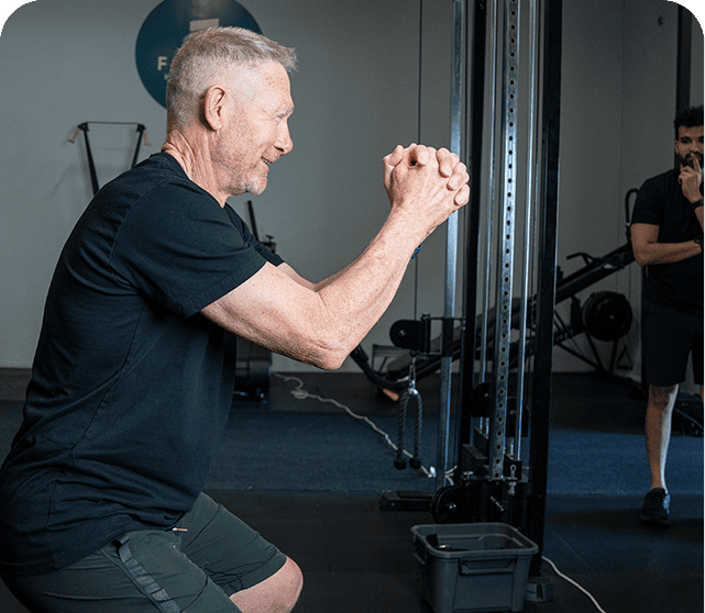 Older adult training with a coach in the studio